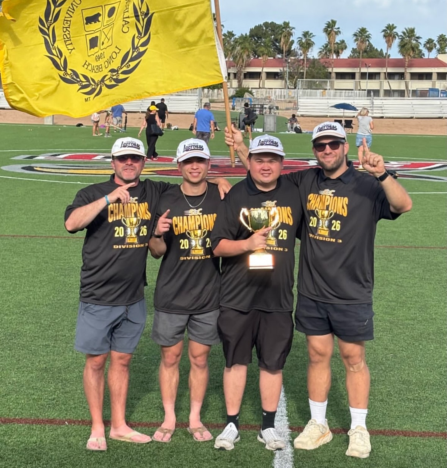 Brett Fink celebrating the 2026 SLC championship with the Cal State Long Beach lacrosse program, holding the trophy and team flag